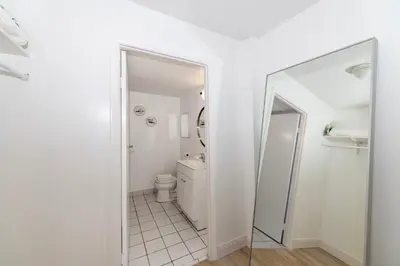 a white bathroom with a toilet and a mirror at South Beach Apartments in Miami Beach