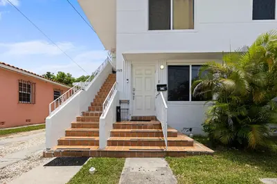 a white house with stairs leading to a door at Enchanting cozy Apartment 10 min away from airport, Calle 8, Brickell, Coral Gables, the beach and more! in Miami