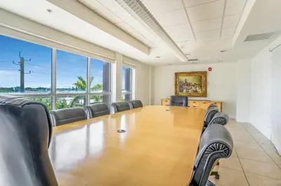 an empty conference room with a large table and chairs at South River Suites in Medley