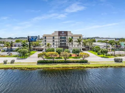 an aerial view of a building with a body of water at South River Suites in Medley