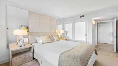 a bedroom with a large white bed and two lamps at Luxurious Private Condo at 1 Hotel & Homes -945 in Miami Beach