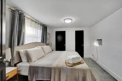 a white bedroom with a bed with a hat on it at Casa Del Sol in Hollywood