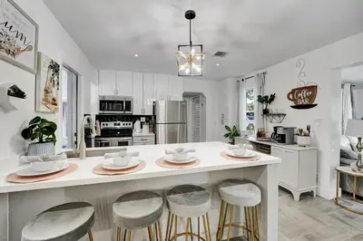 a kitchen with a large island with bar stools at Casa Del Sol in Hollywood