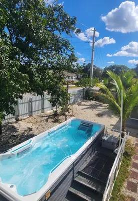 a swimming pool in a yard with a palm tree at Private and beautiful room for vacation in Carver Ranches