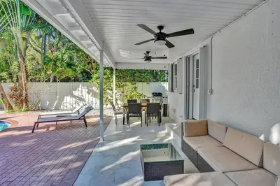 a patio with a couch and a ceiling fan at Beach House w/ Heated Pool in Hollywood