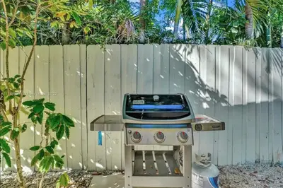 a barbecue grill in a yard next to a fence at Beach House w/ Heated Pool in Hollywood