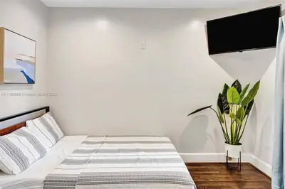 a bedroom with a bed and a tv on the wall at Beach House w/ Heated Pool in Hollywood
