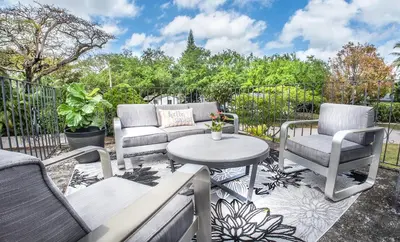a patio with two chairs and a table at Villas at St James Place UNIT F, Luxury, Pet Friendly in Miami
