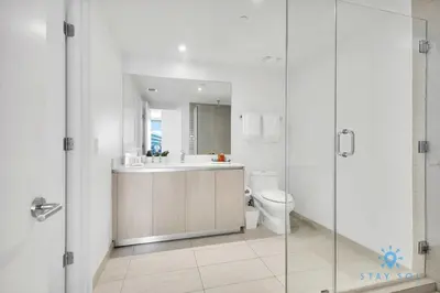 a bathroom with a sink and a toilet and a mirror at Exclusive Condo - Near Beach - Free Valet Parking in Hollywood