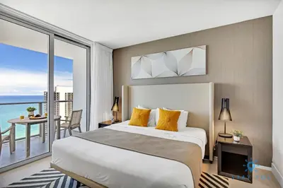 a bedroom with a large bed and a balcony at Exclusive Condo - Near Beach - Free Valet Parking in Hollywood