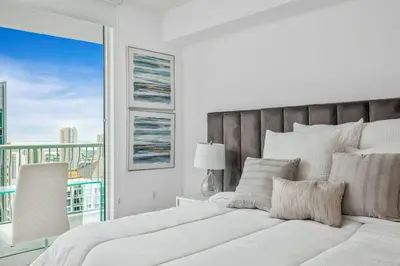 a white bedroom with a large bed and a window at Amazing Penthouse In beautiful Brickell 42 floor!! Free Garage Parking in Miami