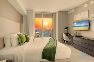 a bedroom with a bed with a desk and a window at Luxury 3 Br - Corner Balcony - Panoramic View - Pools in Hollywood