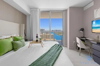 a bedroom with a bed with a desk and a window at Luxury 3 Br - Corner Balcony - Panoramic View - Pools in Hollywood