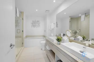 a white bathroom with a tub and a toilet and a sink at Luxury 3 Br - Corner Balcony - Panoramic View - Pools in Hollywood