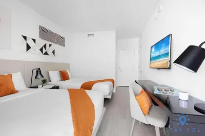 a bedroom with two beds and a desk and a couch at Luxury 3 Br - Corner Balcony - Panoramic View - Pools in Hollywood