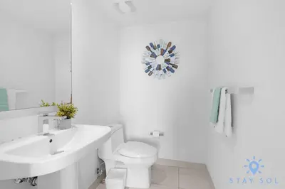 a white bathroom with a sink and a toilet at Luxury 3 Br - Corner Balcony - Panoramic View - Pools in Hollywood