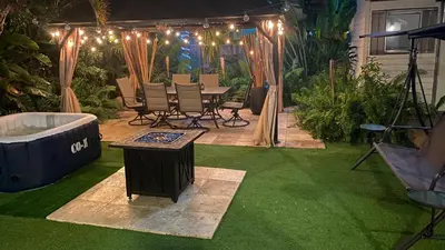 a backyard with a hot tub and a table and chairs at HEART OF WILTON MANORS in Fort Lauderdale
