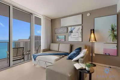 a bedroom with a bed and a couch and a balcony at High Floor 2BR -2 BA - Resort Fees & Parking Incl in Hollywood