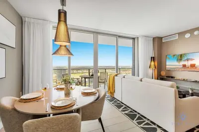 a dining room with a table and chairs and large windows at Amazing Pools - Near Beach - Parking Included in Hollywood
