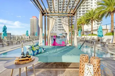 a hotel pool with a bed and a table at Amazing Pools - Near Beach - Parking Included in Hollywood