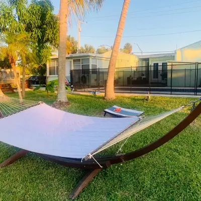 a hammock in the grass in front of a house at Modern Spanish Villa- Pool- By River-Tropical !!! in Fort Lauderdale