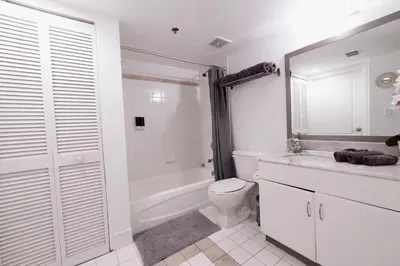 a bathroom with a toilet and a tub and a sink at 4 bed full condo in Miami with skyline & sea view in Miami