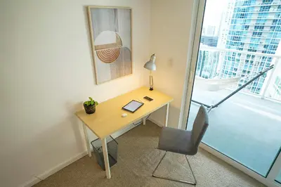 a desk and chair in a room with a window at 4 bed full condo in Miami with skyline & sea view in Miami