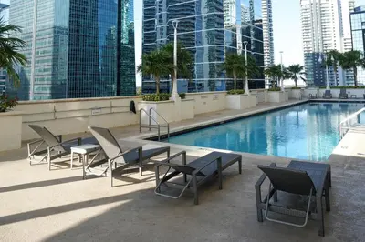 a patio with a table and chairs next to a pool at 4 bed full condo in Miami with skyline & sea view in Miami