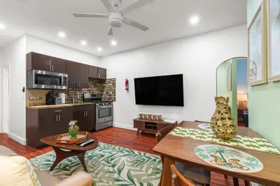 a living room with a table and a kitchen at The Pearl Beachside Apartments on Hollywood Beach in Hollywood