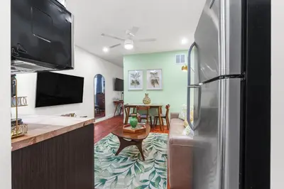 a kitchen with a stainless steel refrigerator and a table at The Pearl Beachside Apartments on Hollywood Beach in Hollywood