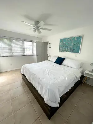 a bedroom with a large bed with a ceiling fan at Downtown FTL apartments on the River in Fort Lauderdale