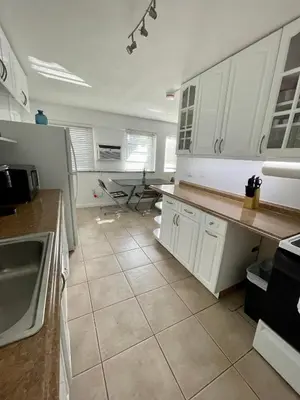 a kitchen with white cabinets and a tile floor at Downtown FTL apartments on the River in Fort Lauderdale