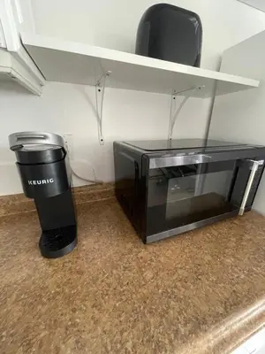 a microwave sitting on a counter next to a trash can at Downtown FTL apartments on the River in Fort Lauderdale