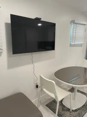a room with a table and a tv on a wall at Downtown FTL apartments on the River in Fort Lauderdale