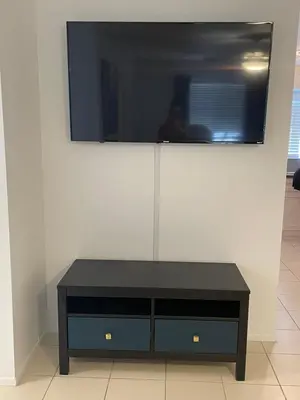 a black entertainment center with a tv on a wall at Cozy Downtown Apartments on Water in Fort Lauderdale