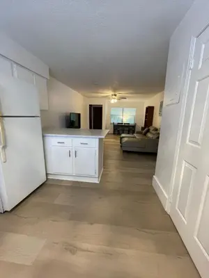 a kitchen with a white refrigerator and a living room at Cozy Downtown Apartments on Water in Fort Lauderdale