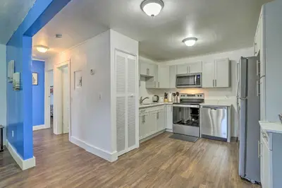 a kitchen with white cabinets and a wooden floor at Beautiful Miami Getaway Less Than 6 Mi to Downtown! in Miami