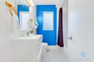 a bathroom with a white toilet and a blue wall at Free Parking - Bay View - Pool - Step To Beach in Hollywood