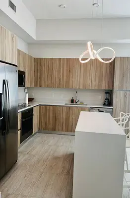 a kitchen with wooden cabinets and a stainless steel refrigerator at BRAND NEW TOP FLOOR IN THE HEART OF MIAMI in Miami