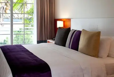 a large bed in a hotel room with a window at Leslie Hotel Ocean Drive in Miami Beach