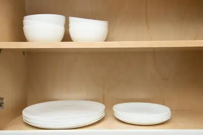 two white plates and bowls on a shelf at The Hideaway at Lake Ridge 3 in Fort Lauderdale