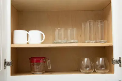 a cupboard filled with glasses and mugs at The Hideaway at Lake Ridge 3 in Fort Lauderdale