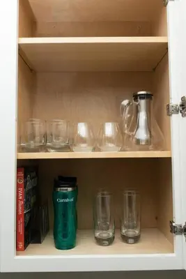 a cupboard with glasses and a green thermos at The Hideaway at Lake Ridge 1 in Fort Lauderdale