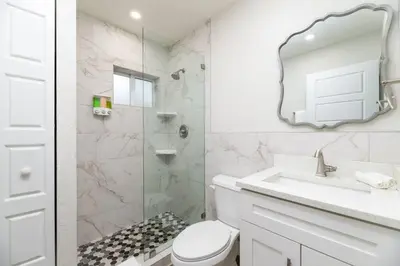 a bathroom with a toilet and a sink and a mirror at The Hideaway at Lake Ridge 1 in Fort Lauderdale
