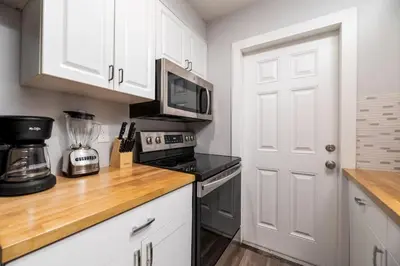 a kitchen with white cabinets and a microwave at The Palms at Middle River Terrace 3 in Fort Lauderdale