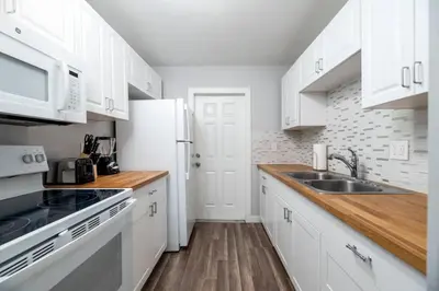 a kitchen with white cabinets and a white refrigerator at The Palms at Middle River Terrace 2 in Fort Lauderdale