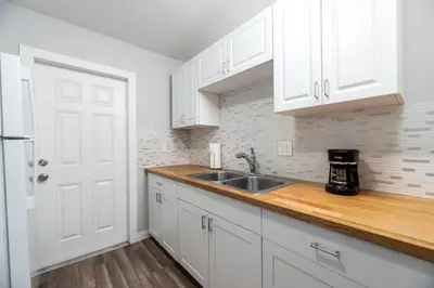 a kitchen with white cabinets and a sink at The Palms at Middle River Terrace 2 in Fort Lauderdale