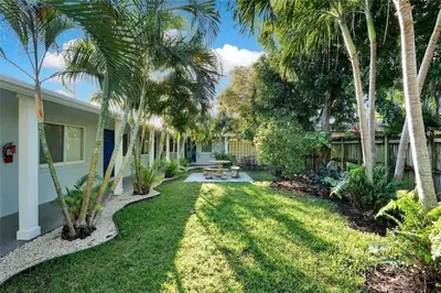 a yard with palm trees and a house at The Palms at Middle River Terrace 2 in Fort Lauderdale