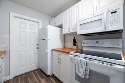 a kitchen with white cabinets and a white stove top oven at The Palms at Middle River Terrace 1 in Fort Lauderdale
