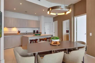 a kitchen and dining room with a table and chairs at Penthouse Condo at Lyfe Resort and Residences in Hollywood